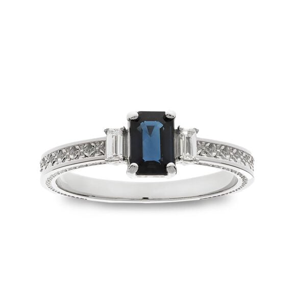 Zlatara as verenički prsten od zlata ili platine, iz memory kolekcije, model k351 sa dragim kamenom plavim safirom, četvrtastog oblika, težine oko 0,67ct, dimenzija oko 6x4mm. Bočno je ugrađeno 2 dijamanata, četvrtastog oblika, težine 0,1ct. Mogućnost ugradnje: laboratorijski dijamant, mojsanit, moissanite