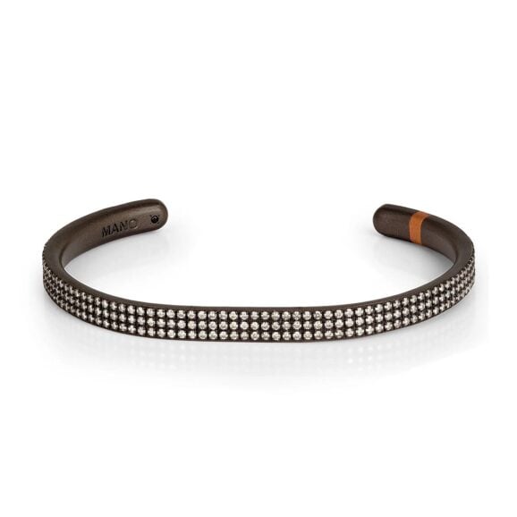 Muška narukvica od titanijuma, 18 kt crvenog zlata i belih dijamanata. Važna i prelepa kruta narukvica od titanijuma na čijoj površini su postavljena u tri paralelna reda 285 belih dijamanata, ukupne težine od 2.85 ct. Prema kraju narukvice umetnut je dragoceni element od 18 kt crvenog zlata. Unutar narukvice nalazi se uvek prisutan crni dijamant od 1 tačke, simbol brenda MANO|J. Jedinstveni i dragoceni dragulj gde su beli dijamanti pravi protagonisti.