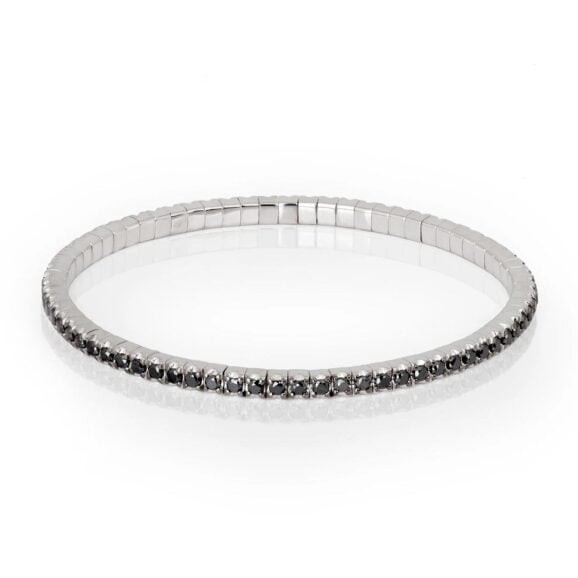 Elastična zlatna tenis narukvica od 9 kt belog zlata (13.02 gr) i crnih dijamanata (2.30 ct), u dve veličine, manja ženska narukvica i veća muška narukvica. Narukvica se sastoji od neprekidnog niza dijamanata iste veličine postavljenih na segmentima od zlata, koji su smešteni jedan pored drugog na elastičnoj vezi. Svaki Crni Dijamant drže po četiri krapne.