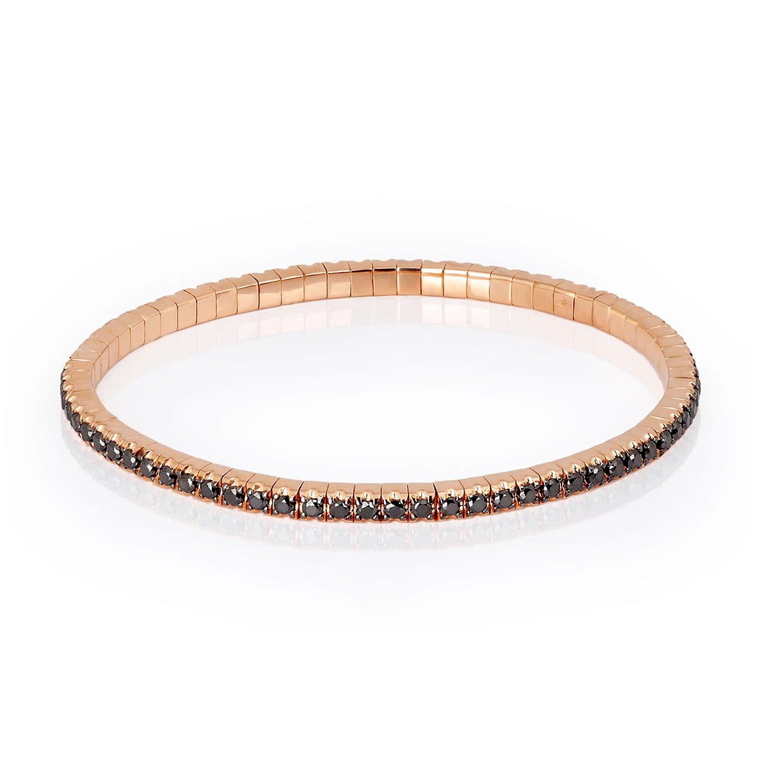 Fleksibilna tenis narukvica od titanijuma, sa dijamantima, model tenbrbor9kt_p-2 Elastična tenis narukvica od 9 kt roze zlata (12,80 gr) i crnih dijamanata (2. 30 ct), u dve veličine, manja ženska narukvica i veća muška narukvica. Narukvica se sastoji od neprekidnog niza dijamanata iste veličine postavljenih na segmentima od zlata, koji su smešteni jedan pored drugog na elastičnoj vezi. Svaki crni dijamant drže po četiri krapne.