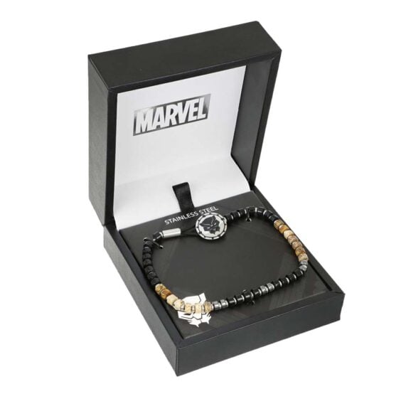 Otvorena marvel kutija sa narukvicom od crnih i zlatnih perli, centralni okrugli privesak sa belom zvezdom u crnom krugu, na tamnoj podlozi