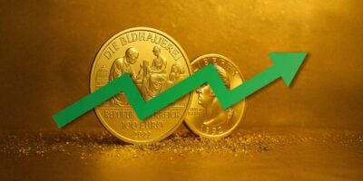 Veći i manji zlatni dukat i zelena strelica koja simbolizuje rast cene zlata